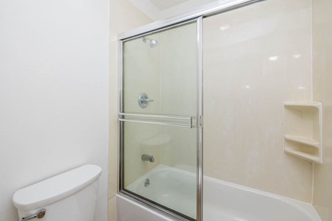 a white bathroom with a shower and a toilet