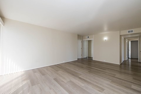 A room with wooden flooring and white walls.