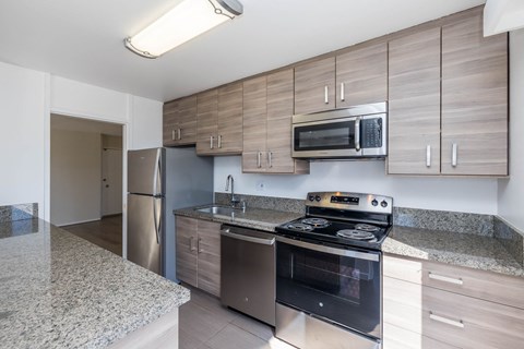 A kitchen with a stove, microwave, and refrigerator.