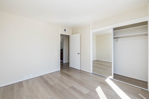 A room with a white wall and a wooden floor.