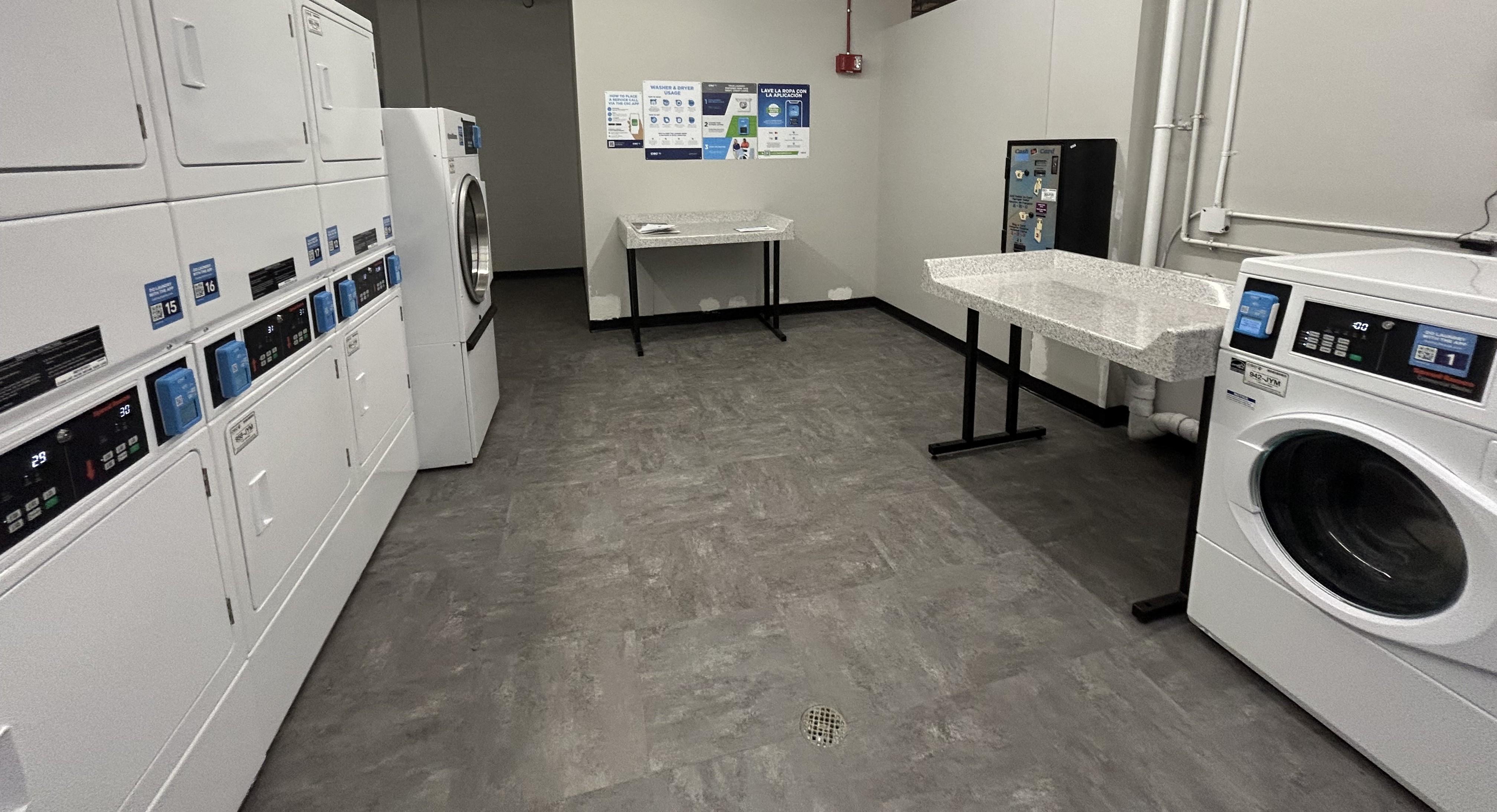 a laundry room with washer and dryers and a table