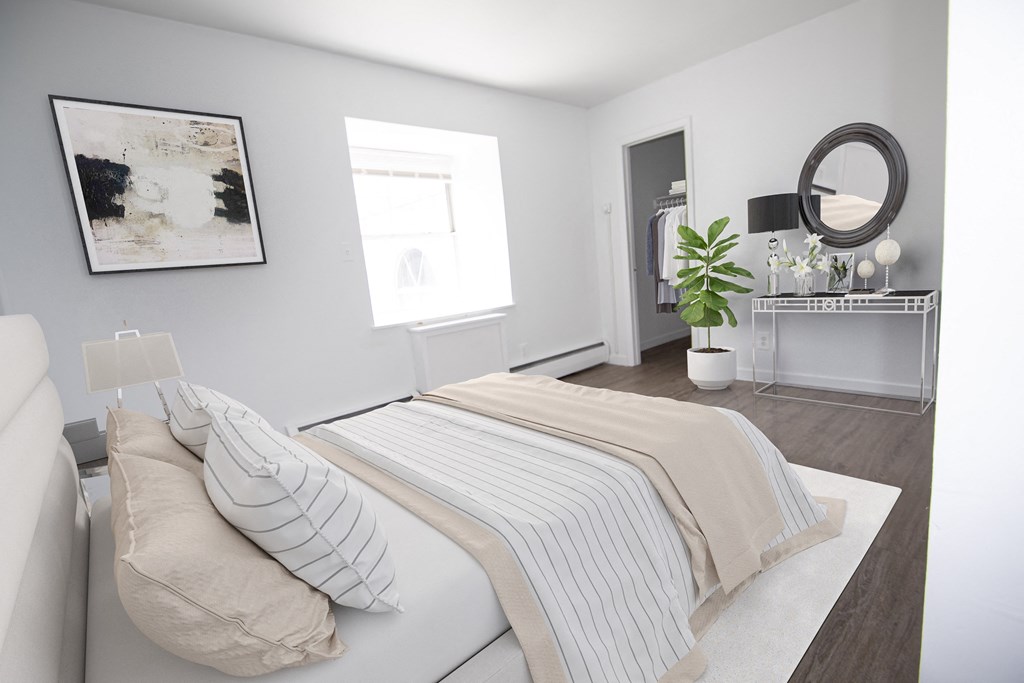 a white bedroom with a bed and a mirror