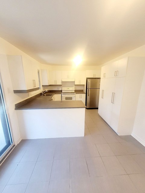 A kitchen with white cabinets and a stainless steel counter.