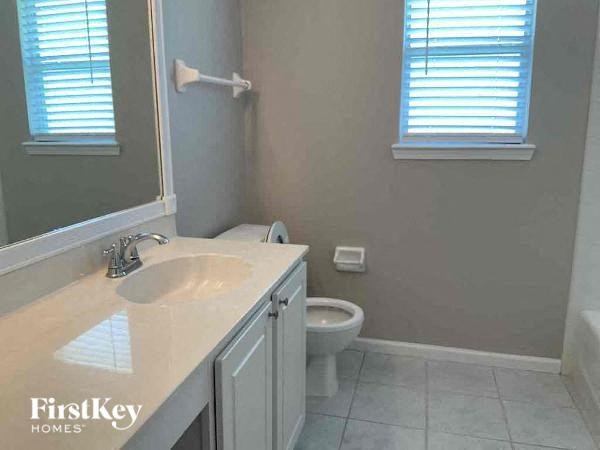 a bathroom with a toilet and a sink and a mirror