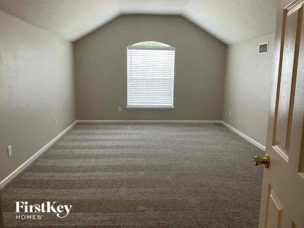 an empty room with a large window and carpet