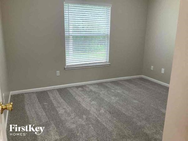 an empty room with a window and a carpet