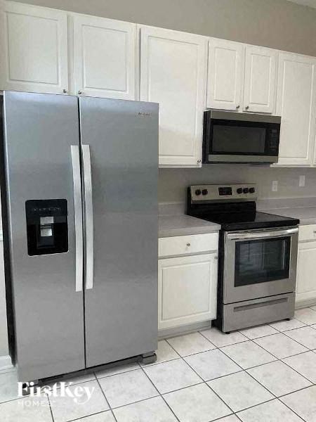 a kitchen with a stainless steel refrigerator and a stove