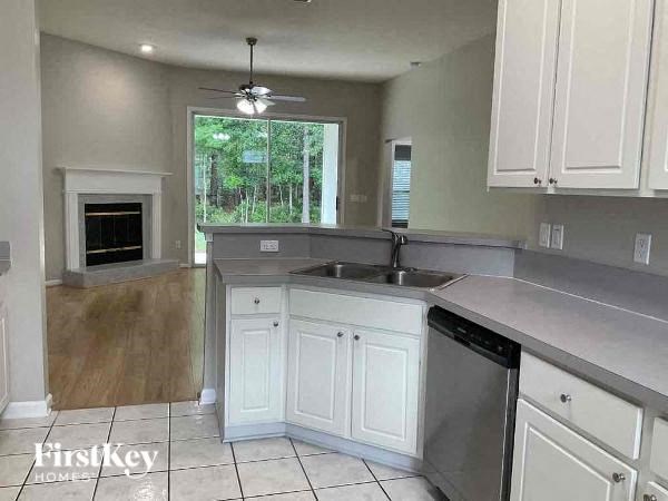 an empty kitchen with white cabinets and a sink