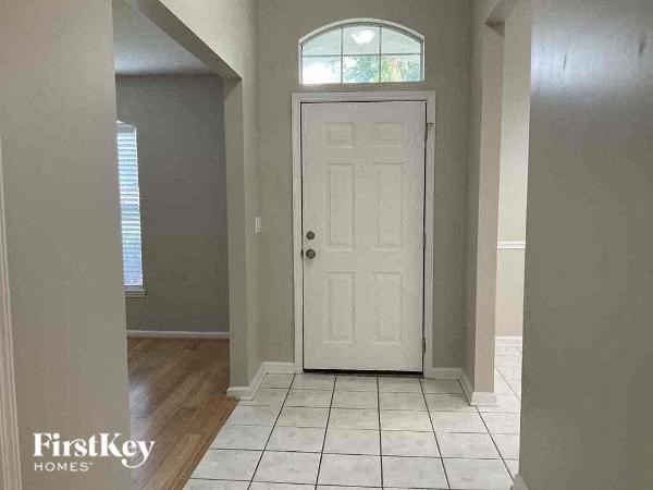 a hallway with a white door and a tiled floor