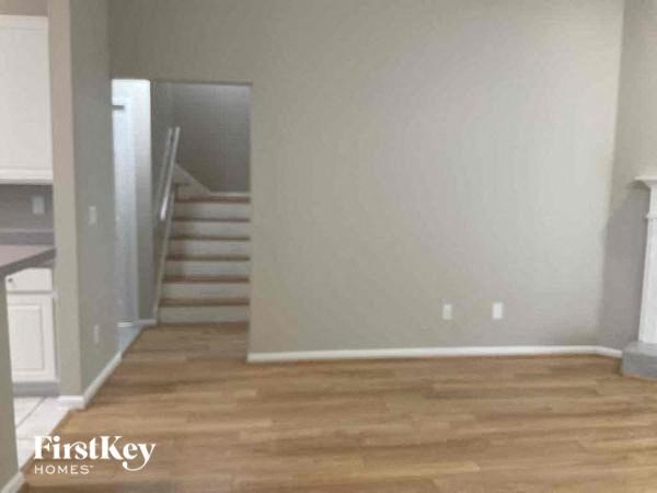 an empty living room with a wooden floor and stairs