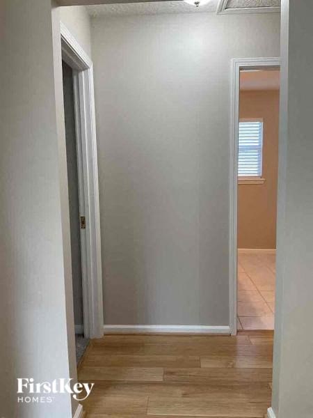 a hallway with a door to a room and a window