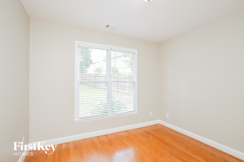 a empty room with a window and wooden floors