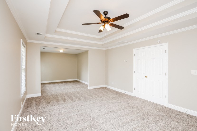 an empty living room with a ceiling fan