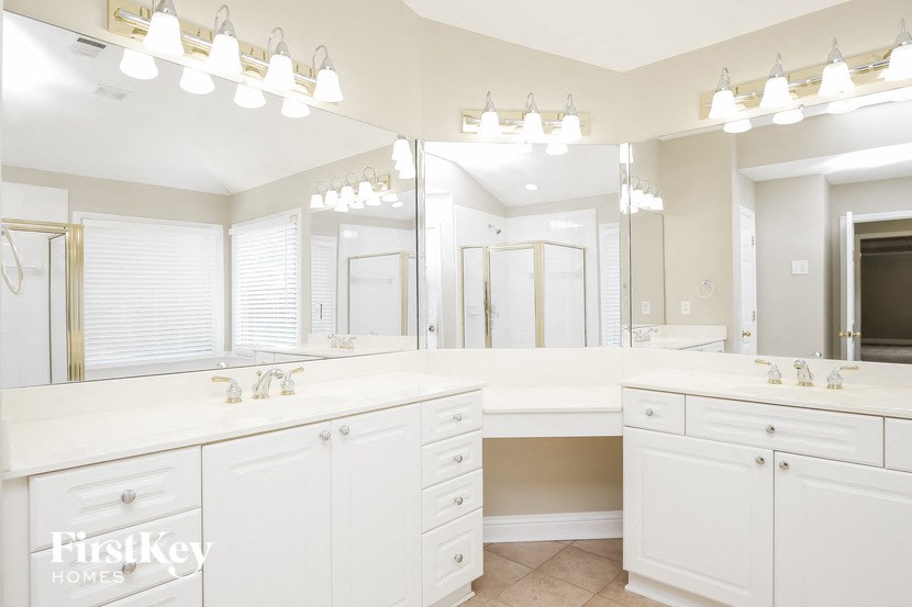 a large white bathroom with two sinks and a large mirror