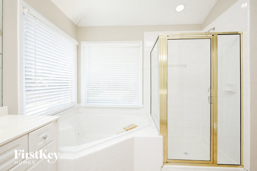 a white bathroom with a shower and a tub