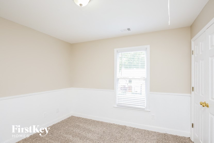 a bedroom with white walls and a window and a white door