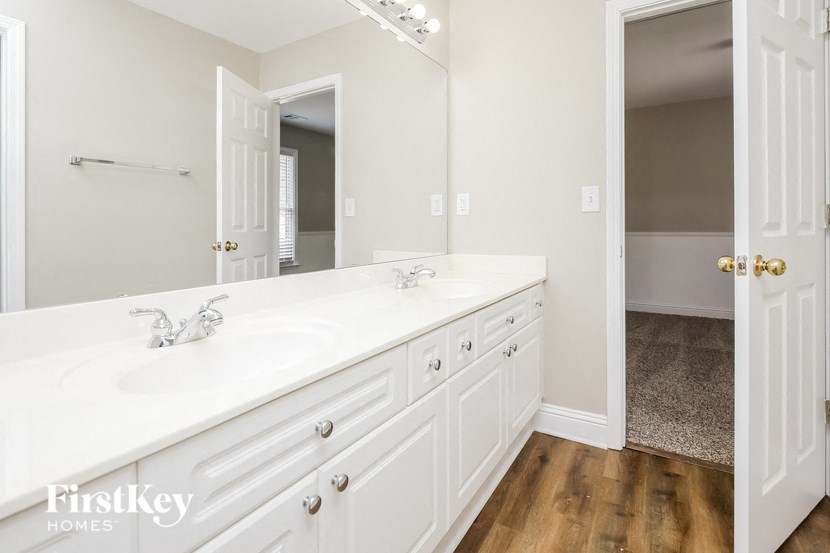 a white bathroom with two sinks and a large mirror
