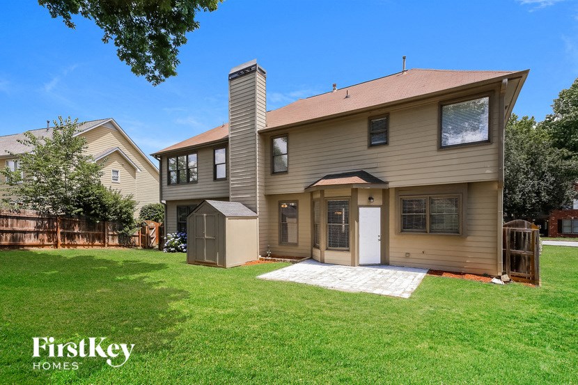 a house with a yard and a shed on the side of it