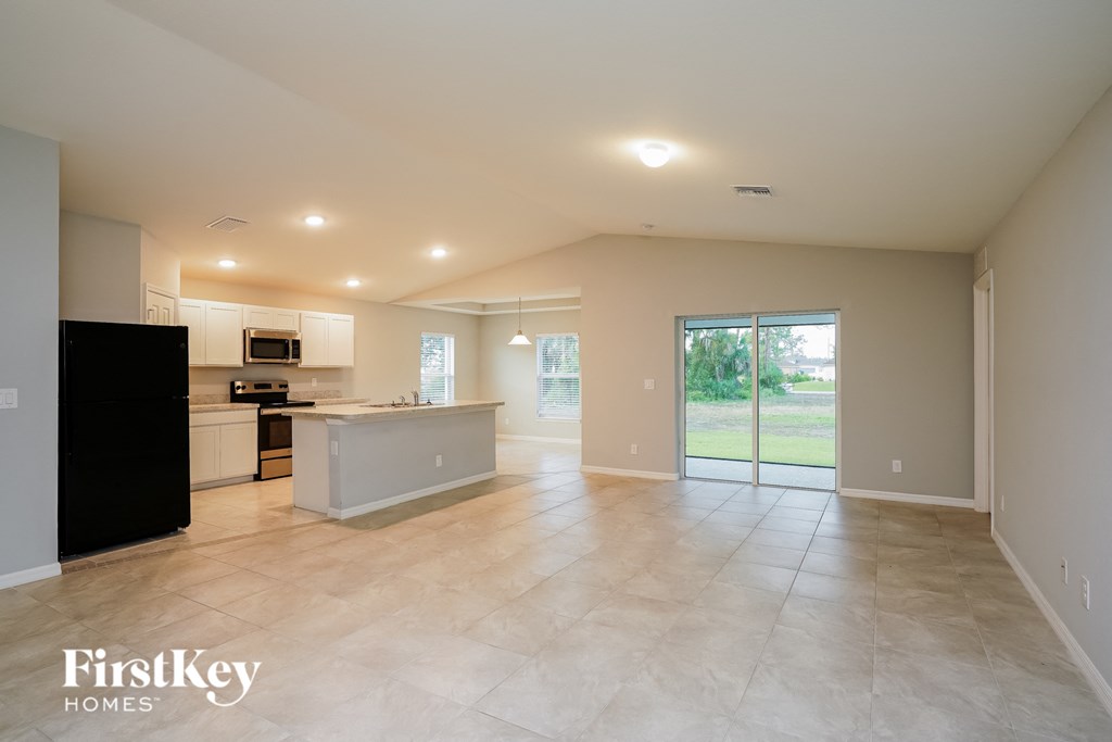 an empty kitchen and living room with a door to the backyard