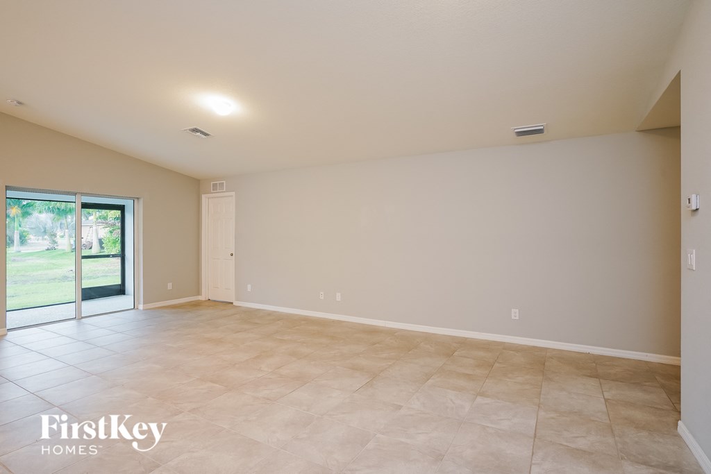 a empty living room with a sliding glass door to the patio