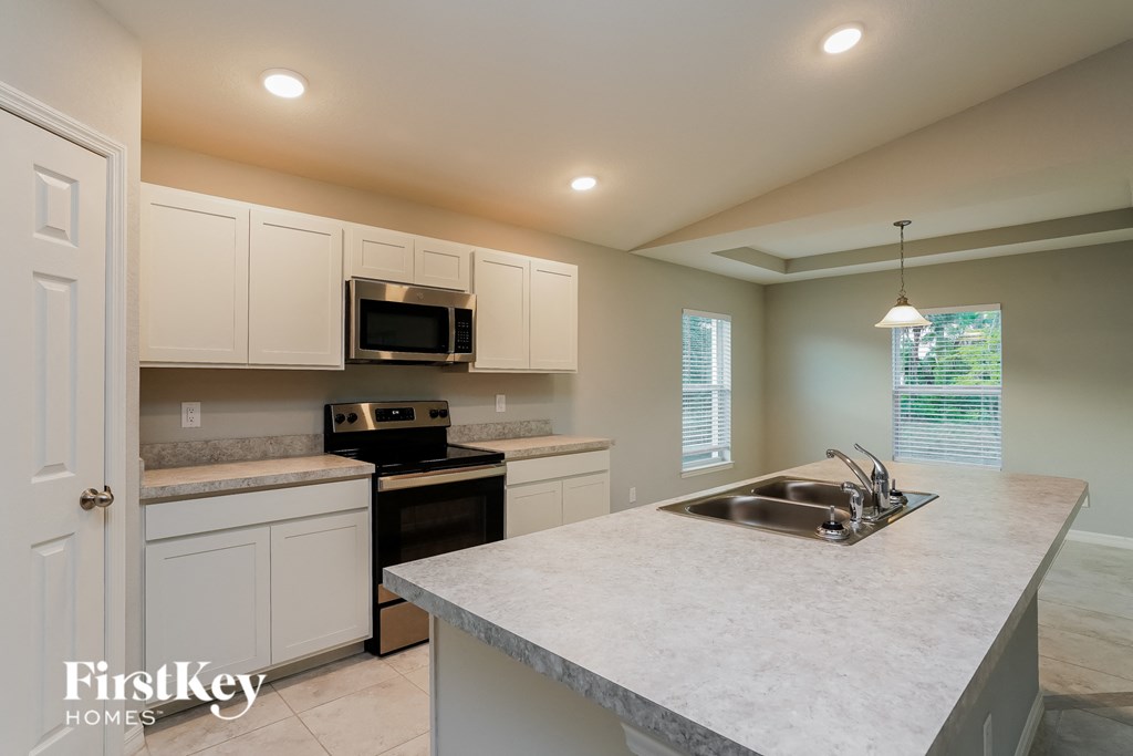 a kitchen with white cabinets and a sink