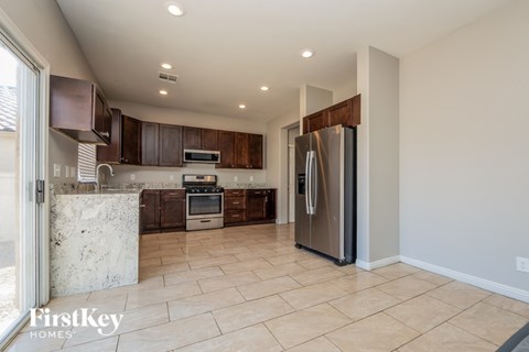 A kitchen with a refrigerator, oven, and microwave.