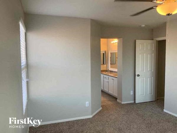 an empty living room with a bathroom and a ceiling fan