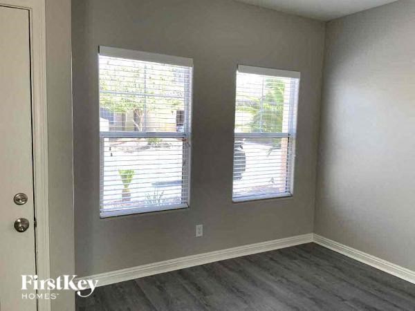 two windows in an empty room with wood floors