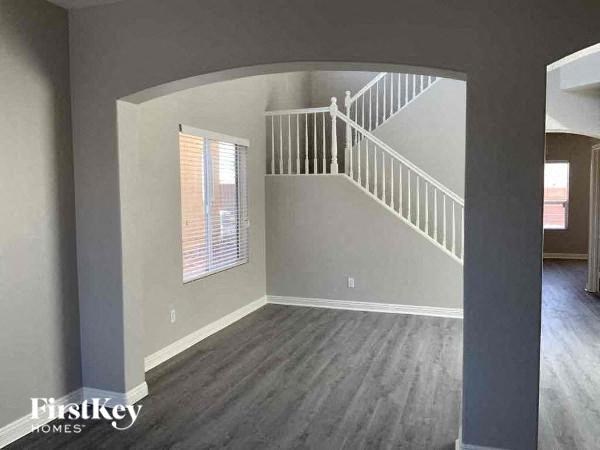 an empty living room with a white staircase
