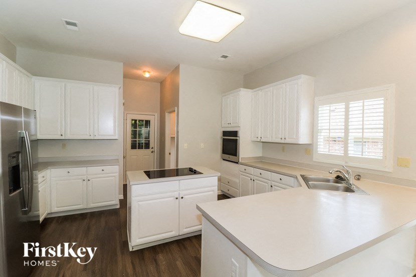 an empty kitchen with white cabinets and white counter tops
