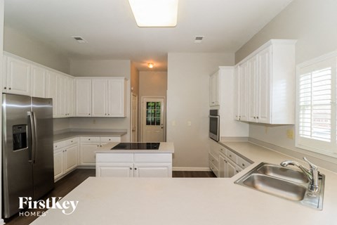 a white kitchen with a sink and a refrigerator