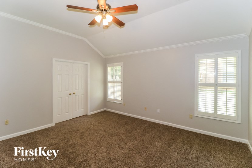 a empty room with a ceiling fan and a window
