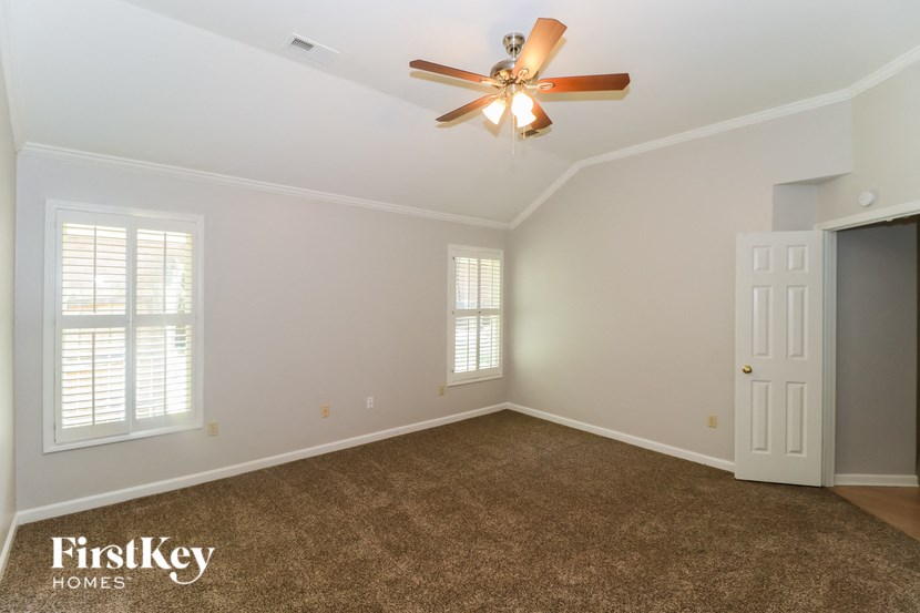an empty room with a ceiling fan and a door