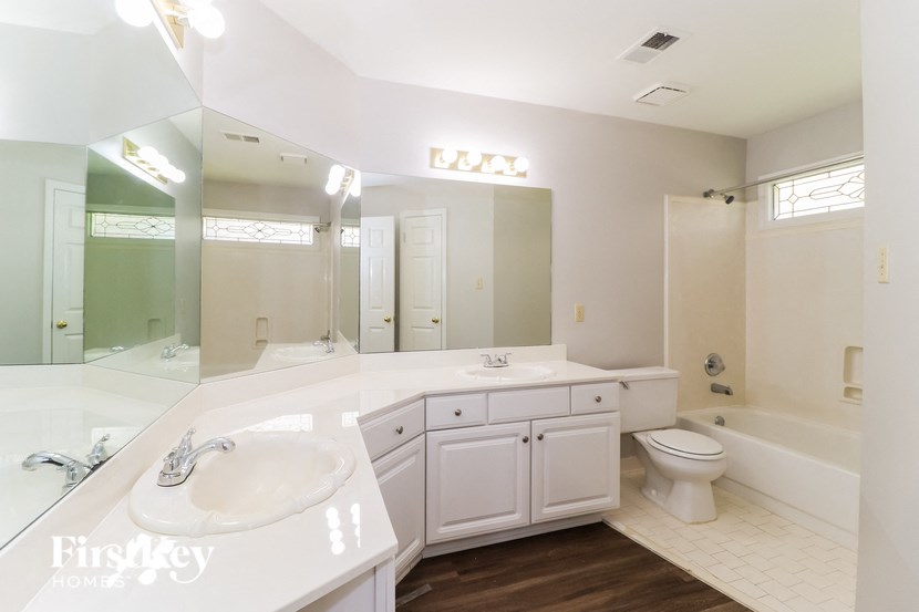 a bathroom with a sink toilet and a mirror