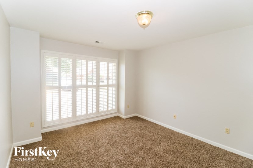 a empty living room with white walls and a large window