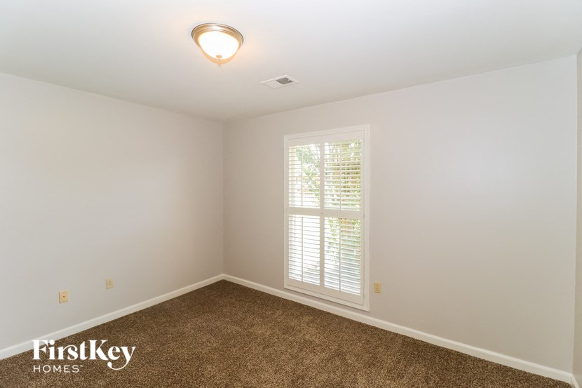 a empty room with a window and a carpet