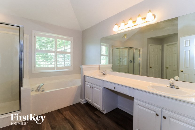 a bathroom with a large mirror and a sink and a tub