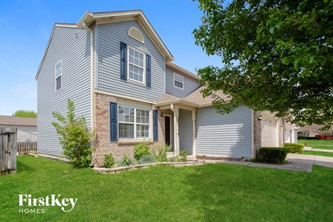 a blue house with white siding and a green lawn