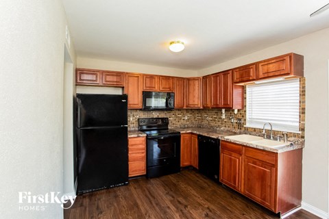 a kitchen with black appliances and wooden cabinets