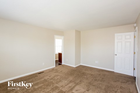 a living room with carpet and a white door