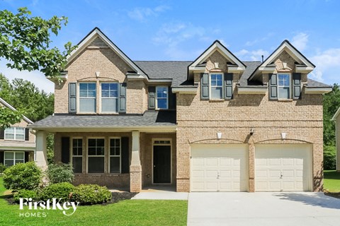 a tan brick house with two garage doors