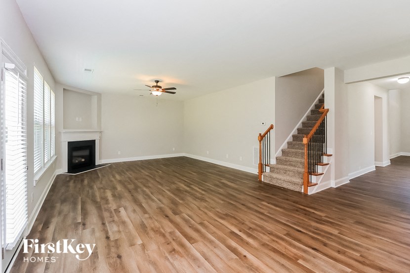 a living room with wood flooring and a fireplace and a staircase