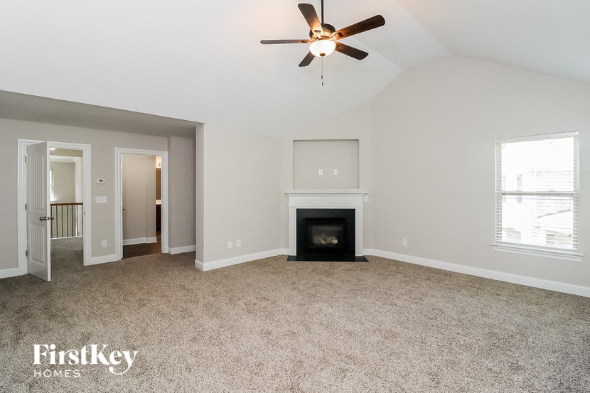 a living room with a fireplace and a ceiling fan