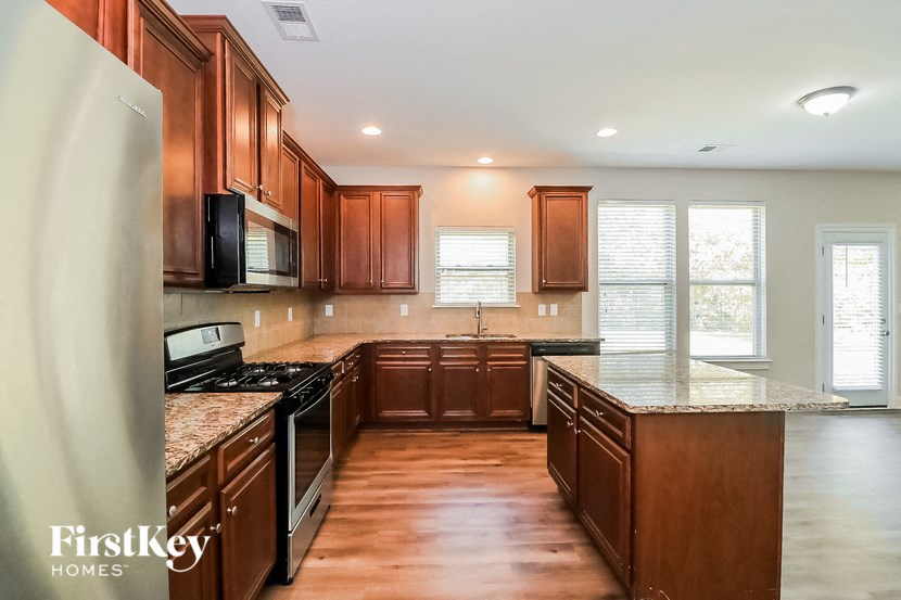 a kitchen with wooden cabinets and granite counter tops and stainless steel appliances
