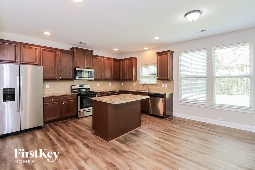 a kitchen with wooden floors and stainless steel appliances
