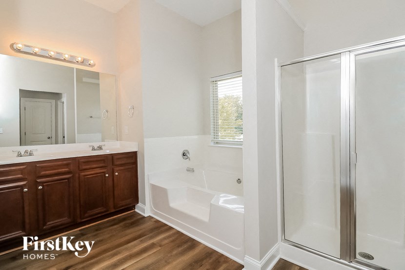 a bathroom with a tub and a shower and a sink