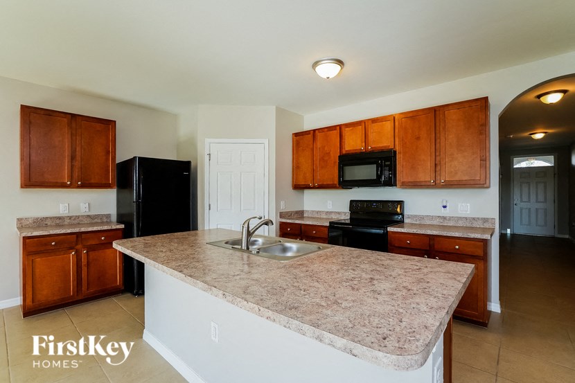a kitchen with granite counter tops and wooden cabinets