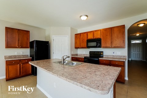 a kitchen with granite counter tops and wooden cabinets