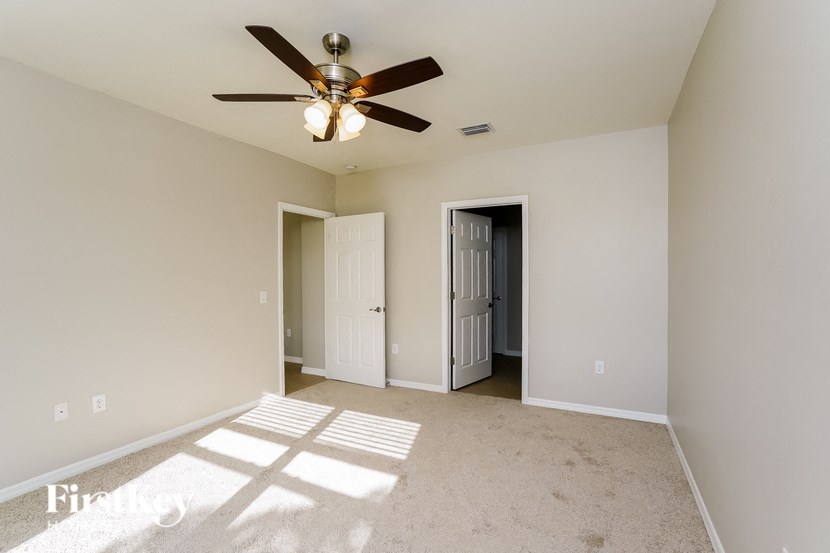 a empty living room with a ceiling fan