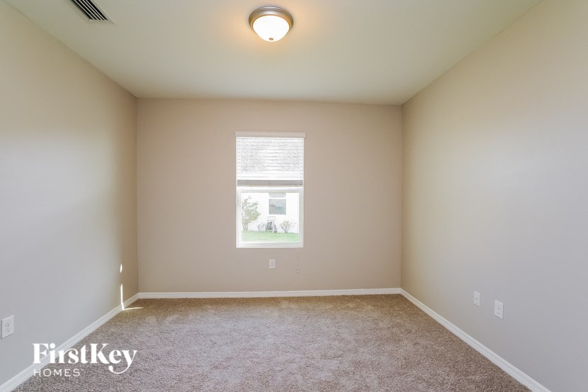 a empty room with a window and a carpet